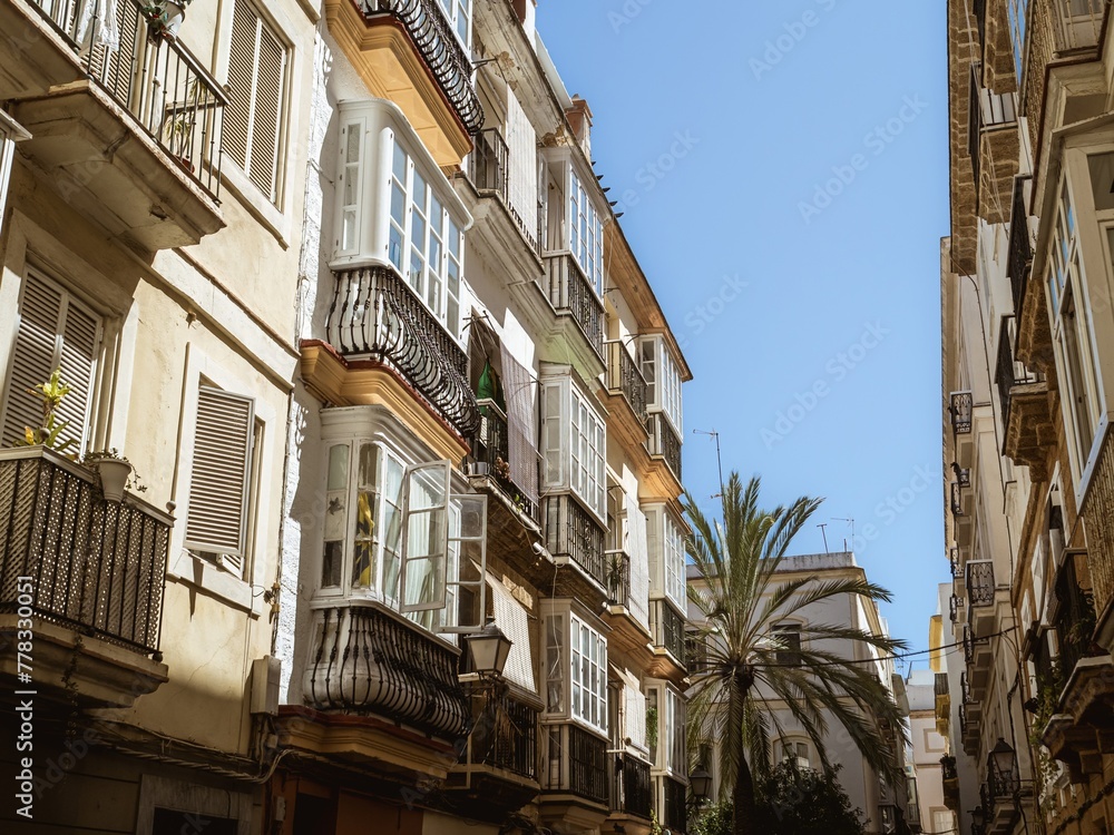 A typical white yellow facade of a residential house in Cadiz, Andalusia, Spain