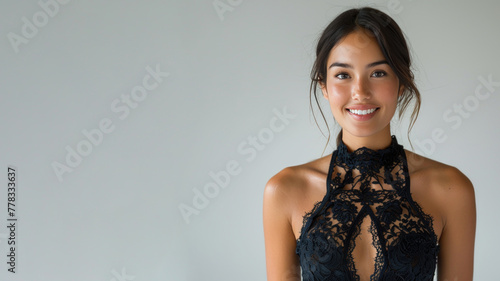 Hispanic elegant woman in black halter neck dress isolated on gray