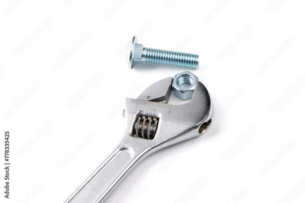 An adjustable wrench with a bright steel or stainless steel hex carriage bolt and hex nut isolated on white An adjustable wrench with a bright steel or stainless steel hex carriage bolt and hex nut isolated on white