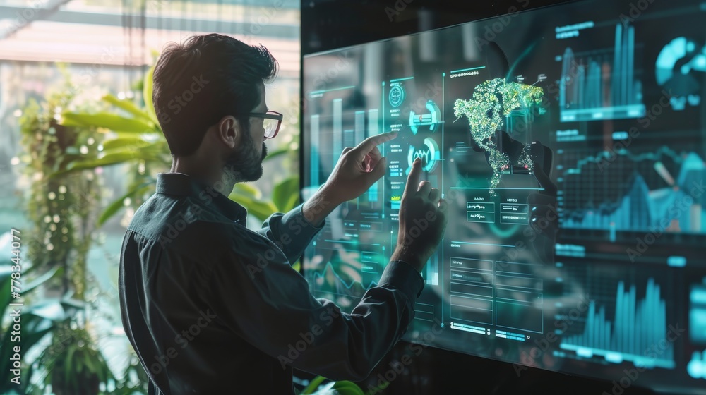 A data analyst focused on an interactive screen displaying futuristic data analytics in a high-tech office environment with plant life.