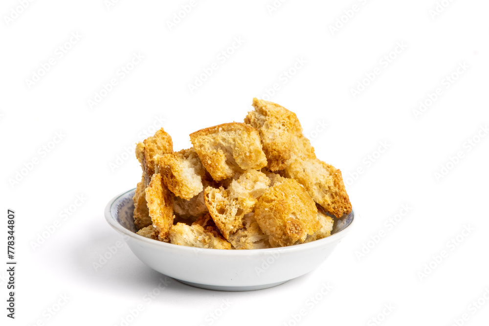 A small dish of toasted seasoned garlic and parmesan soup or salad croutons isolated on white A small dish of toasted seasoned garlic and parmesan soup or salad croutons isolated on white