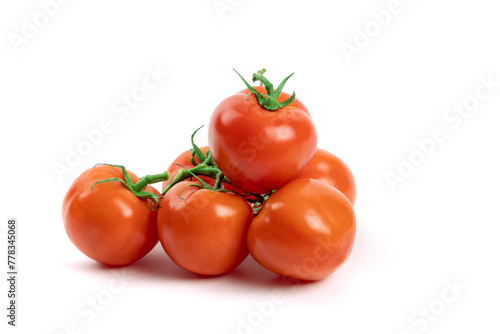 A bunch of fresh ripe red greenhouse tomatoes on the vine isolated on white