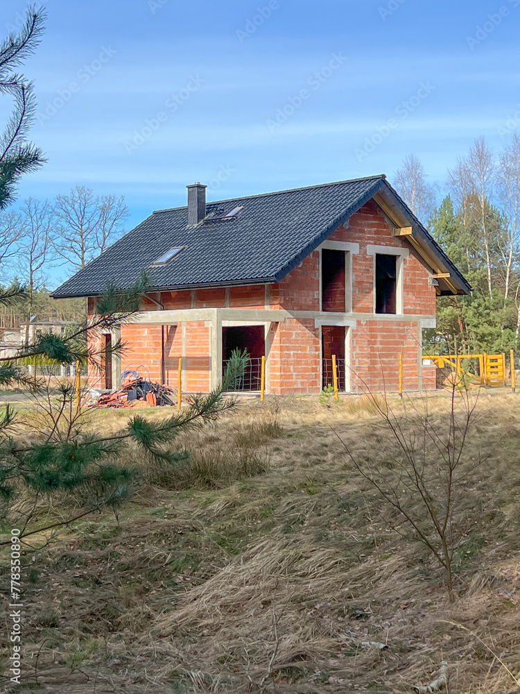 Fototapeta premium A single-family house built of ceramic blocks with a tile roof in a shell state.