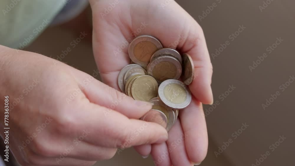 Man counts Thai baht coins while holding them in hand close-up. Concept of economic crisis, inflation, bankruptcy. Man counts Thai baht coins while holding them in hand close-up. Concept of economic crisis, inflation, bankruptcy.
