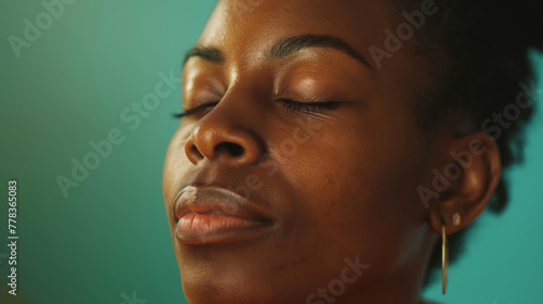 Close-up of a professional woman's face with eyes closed, enjoying a moment of peace during a virtual networking session photo