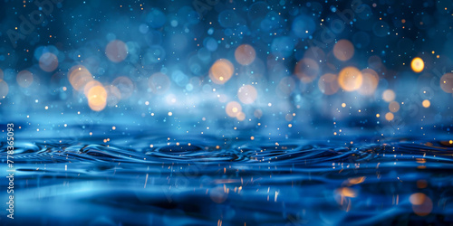 Glistening water background with blurred light dots in a cool blue tone photo
