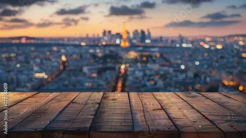 Blurred city view with wooden plank foreground - This image portrays a soft focus city vista at dusk with dewy wooden planks in the foreground, providing depth and context photo