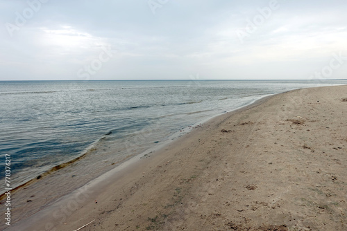 Calm waves of the Baltic Sea in the Gulf of Riga in Jurmala on empty beach on a overcast day in low season