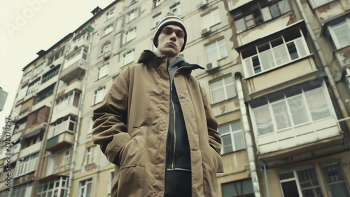 Wallpaper Mural A young Soviet-style teenager poses against a backdrop of 1990s apartment buildings, embodying street fashion trends and evoking nostalgia for the aesthetics and cultural influences of the Soviet era. Torontodigital.ca