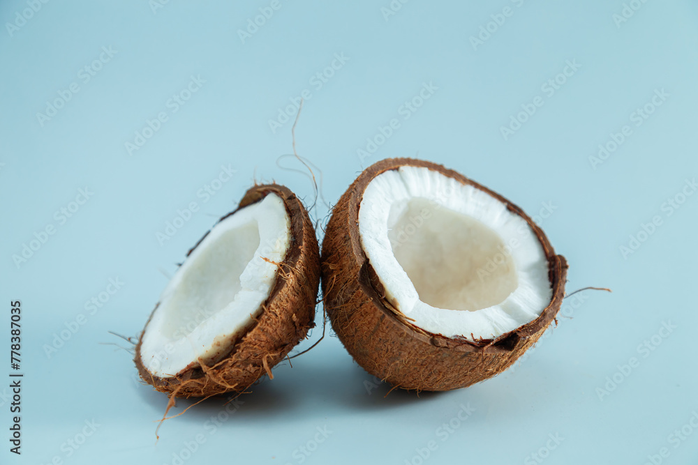 Broken coconut pieces on a blue background. Broken coconut pieces on a blue background.