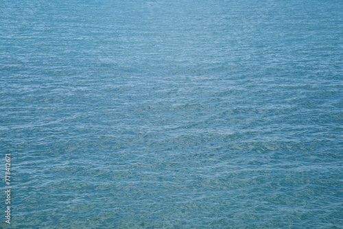 Azure blue texture of waves on the sea. Even background of slight ripples on the water.