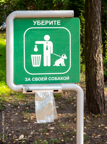 A stand with bags for cleaning up after animals in the park. Translation of the inscription: "Clean up after your dog"