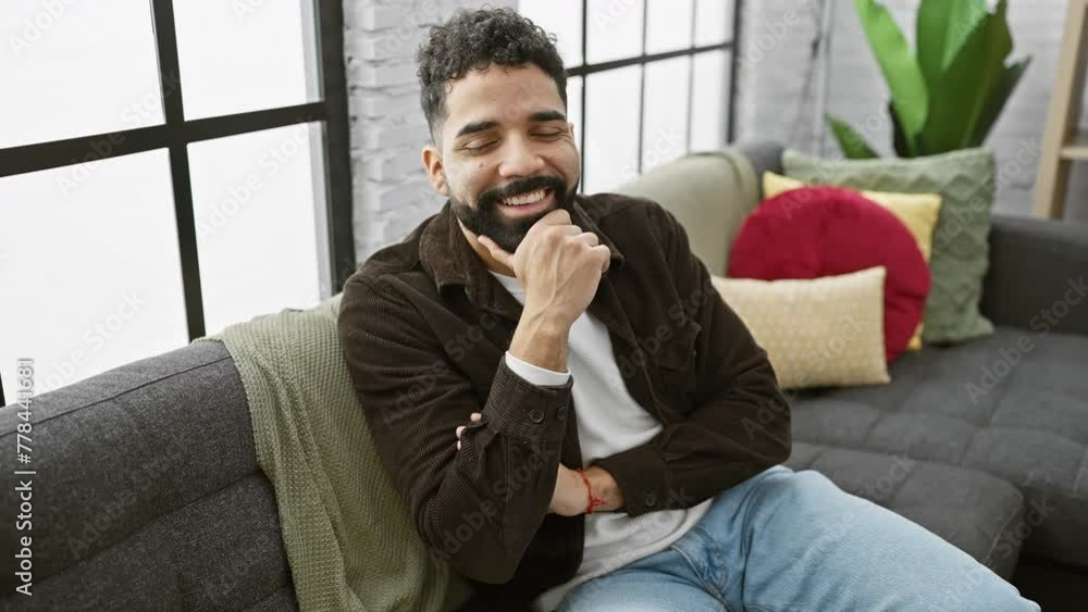Cheerful, confident young man, arms crossed, hand on chin, smiling at the camera. indoors, feeling positive, basking in success at home! Cheerful, confident young man, arms crossed, hand on chin, smiling at the camera. indoors, feeling positive, basking in success at home!