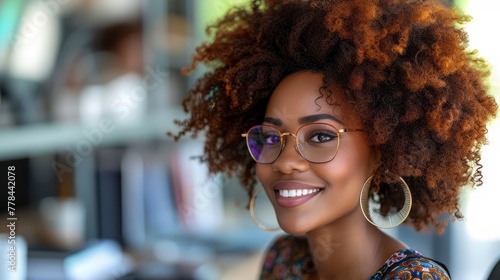 a close up of a person wearing a pair of glasses and a afro with a big smile on her face.