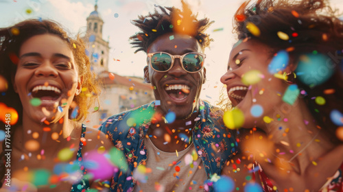 A group of exuberant individuals is tossing confetti and laughing on a rooftop at sunset.