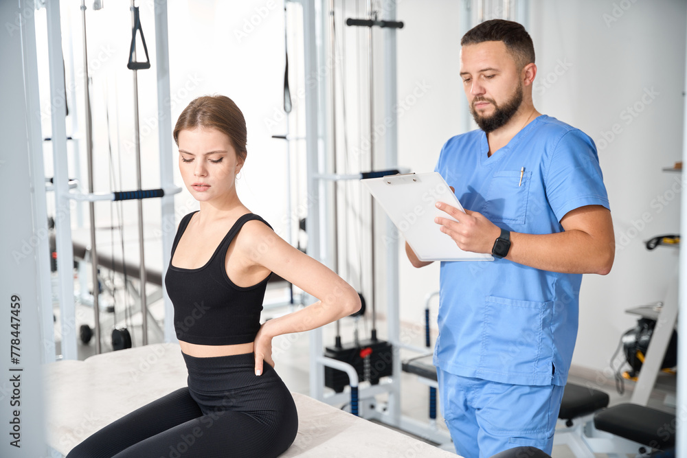 Doctor questioning female patient in kinesiology clinic Doctor questioning female patient in kinesiology clinic