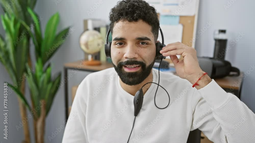 A cheerful young man with a headset in a modern office. A cheerful young man with a headset in a modern office.