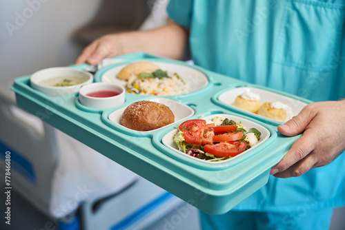 Photography Male nurse is serving dietary meal in medical facility ward