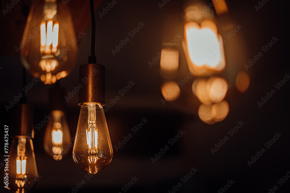 Warm light bulb hanging on dark background Warm light bulb hanging on dark background
