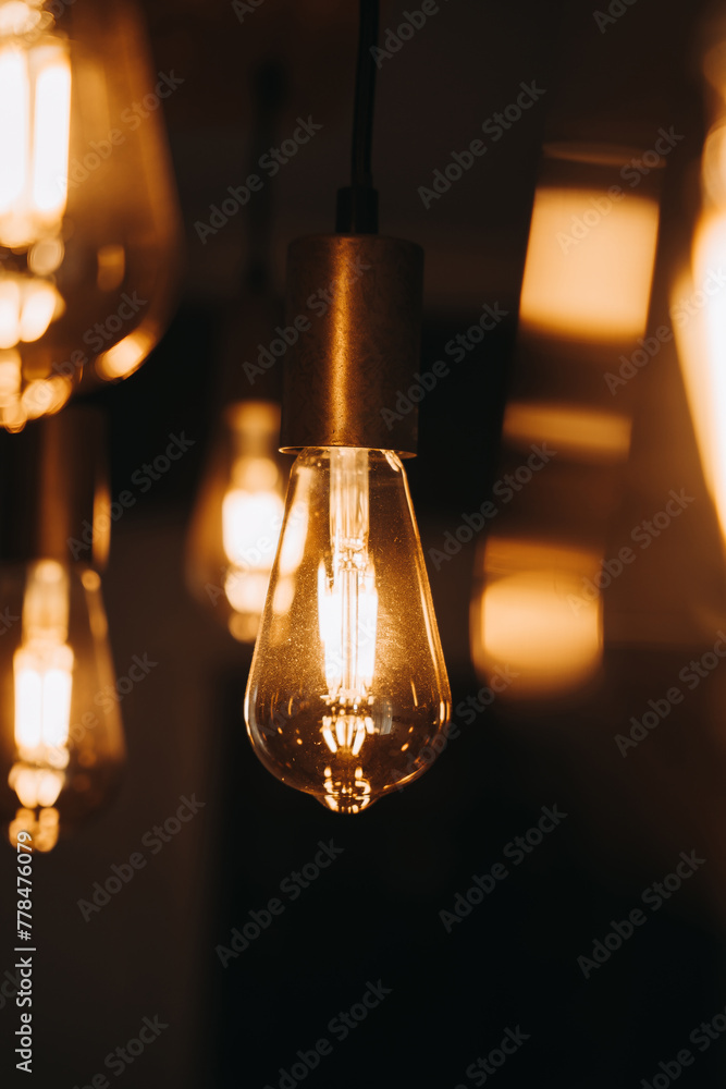 Warm light bulb hanging on dark background Warm light bulb hanging on dark background