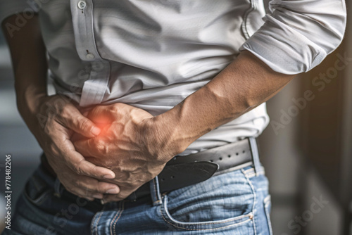 holding lower abdomen in pain with blurred background