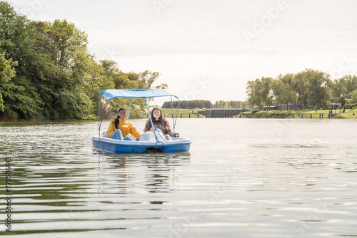 mother and daughter riding a pedal boat on the river enjoying the day off