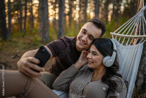Man and woman young adult couple in nature listen music headphones © Miljan Živković