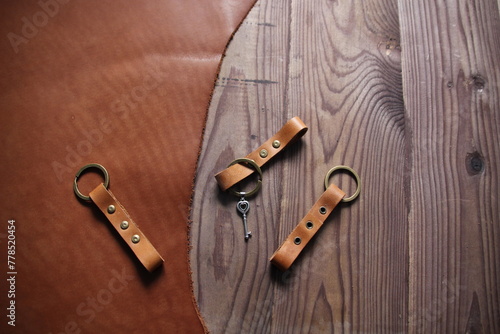Leather hand made craft keychain on brown wooden background