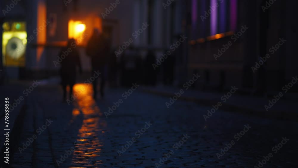 Urban rain dance: Amidst defocused city lights, figures move gracefully through the rain-soaked streets, their blurred forms adding a sense of mystery and intrigue to the nocturnal scene. Urban rain dance: Amidst defocused city lights, figures move gracefully through the rain-soaked streets, their blurred forms adding a sense of mystery and intrigue to the nocturnal scene.