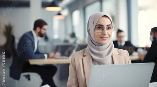 Beautiful muslim woman in hijab using laptop at office workplace. business concept