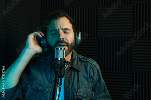 Male vocalist recording song in studio