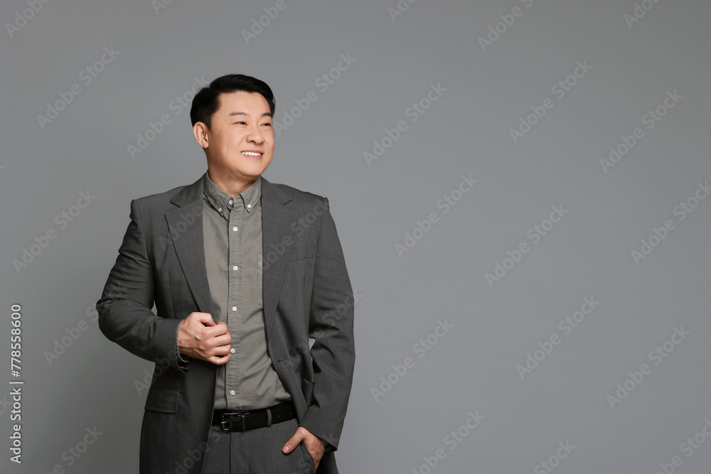 Portrait of happy businessman on grey background. Space for text Portrait of happy businessman on grey background. Space for text