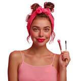 Young woman with makeup brushes and cheerful expression