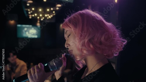Woman with pink hair Singing Karaoke and holding a Cigarette