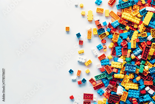 White background, white space in the center of picture. A pile of colorful Lego blocks scattered all over the place. The lego bricks of different shapes and sizes to show diversity.  photo