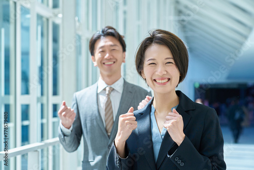 笑顔で応援するスーツ姿の男女 photo