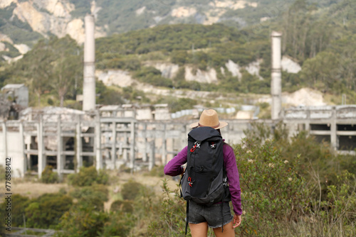 Backpacking woman visiting factory ruins © Fernando