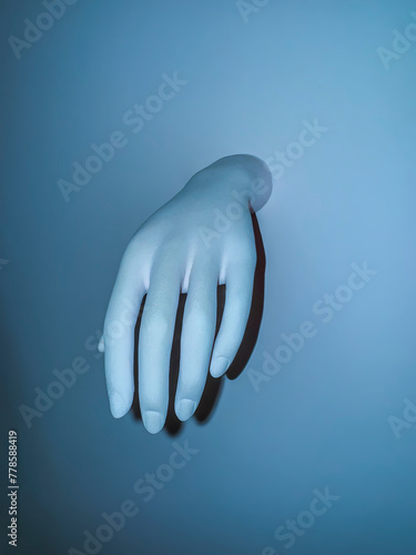 Dummy hand on a blue background. Space for text.