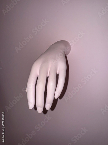 Mannequin hand on a pink background. Space for text.