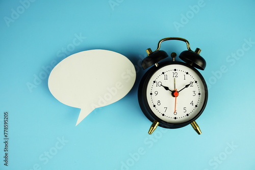 Speech Bubble and alarm clock on blue background