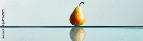 A minimalist still life of a single perfectly juicy pear on a sleek