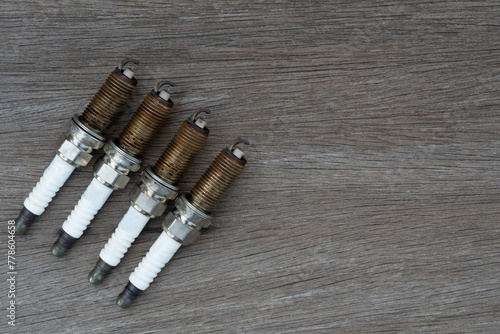 Old spark plugs on the wooden table background.