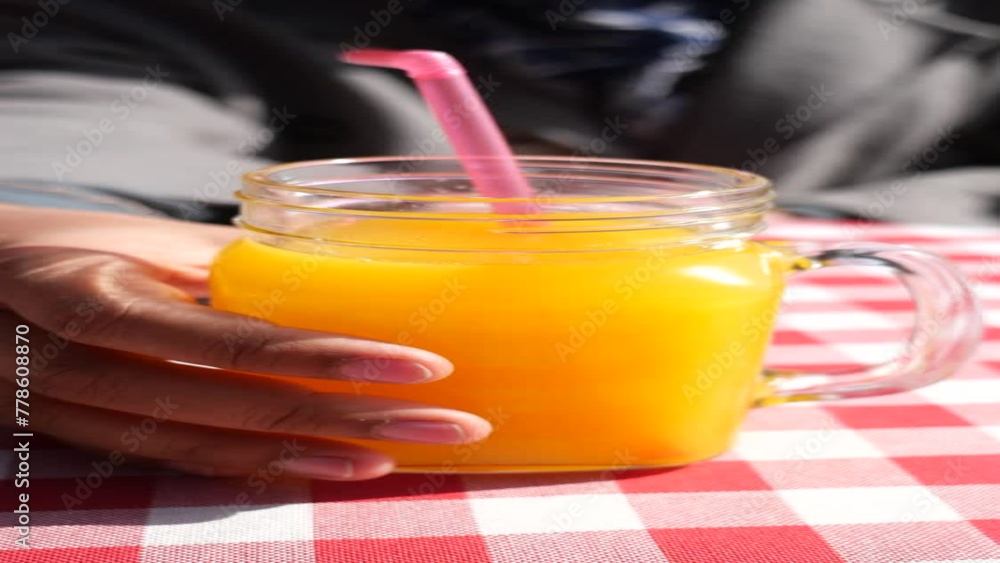 women hand holding a glass of orange juice women hand holding a glass of orange juice