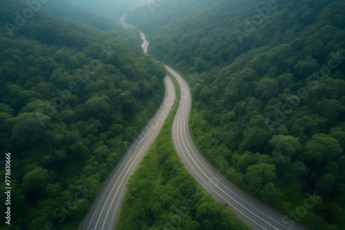 Aerial top view beautiful curve road on green forest in the rain foggy season.