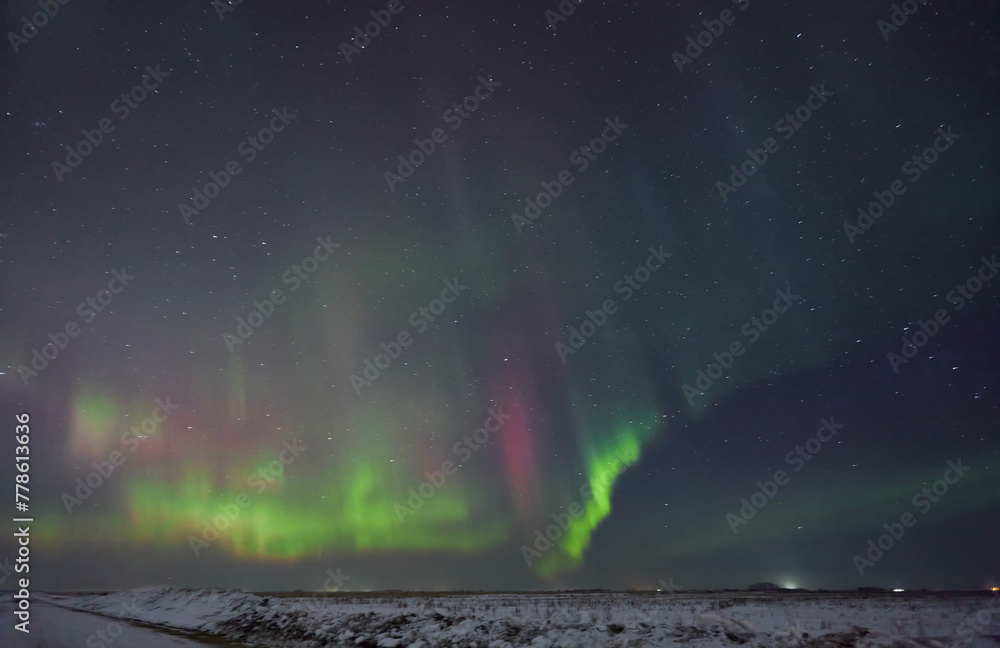  Witness nature's spectacular light show as vibrant ribbons of color swirl and cascade across the Arctic sky, painting a mesmerizing tableau of celestial beauty. 