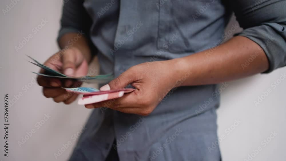 Man hands is calculating a hundred Indonesian thousand rupiah bill manually. Man hands is calculating a hundred Indonesian thousand rupiah bill manually.