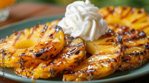 Grilled pineapple slices caramelized and served with a dollop of whipped cream  photo