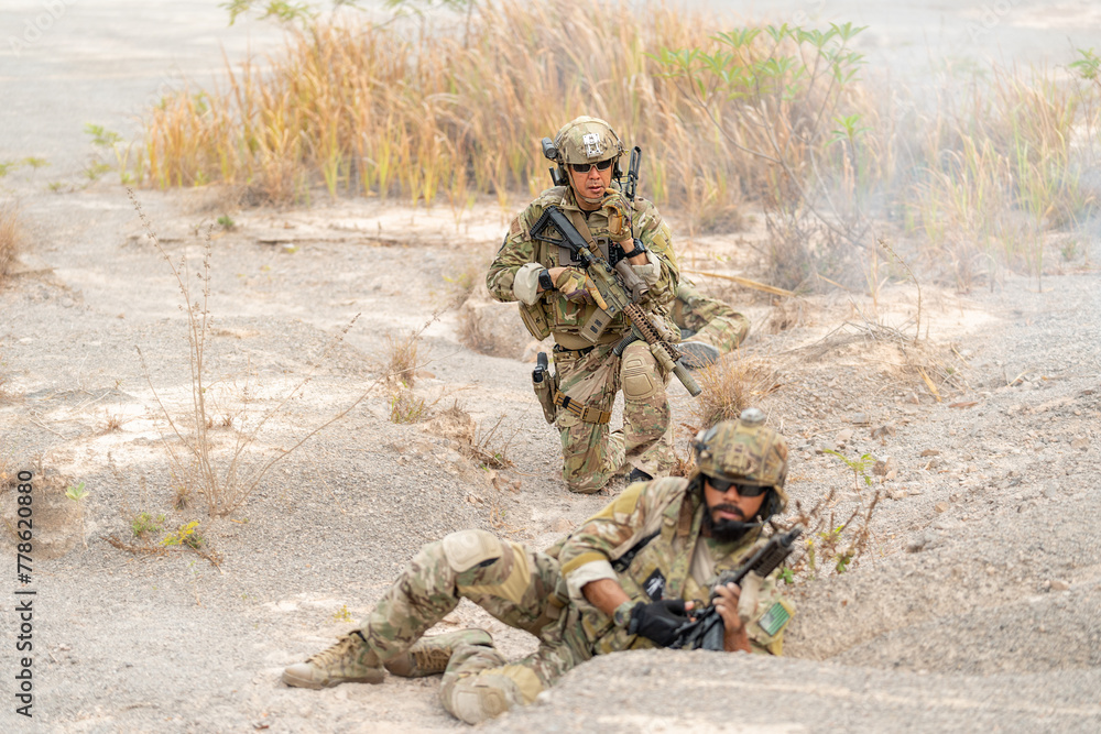 One of soldier or military lie down and look at camera and the other one sit in the position of ready to fighting during outdoor practice. One of soldier or military lie down and look at camera and the other one sit in the position of ready to fighting during outdoor practice.