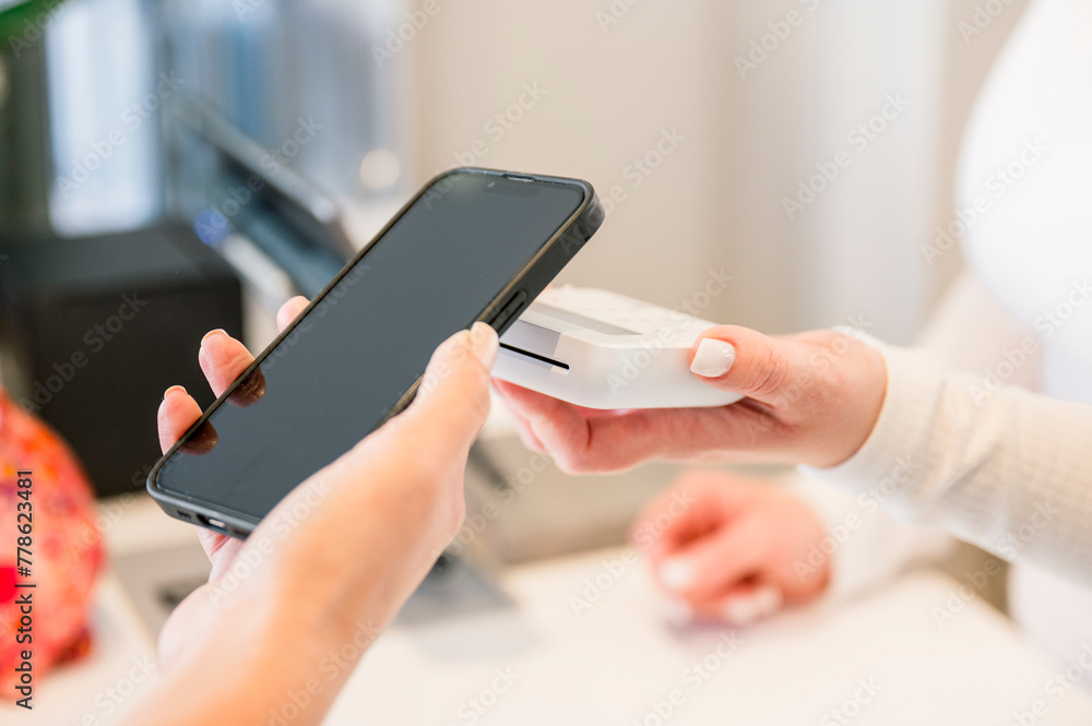 A woman paying something with her mobile phone