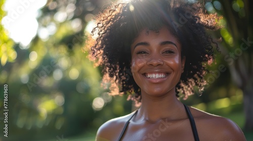 Happy African woman doing regular exercise outdoors at a city park, focusing on face